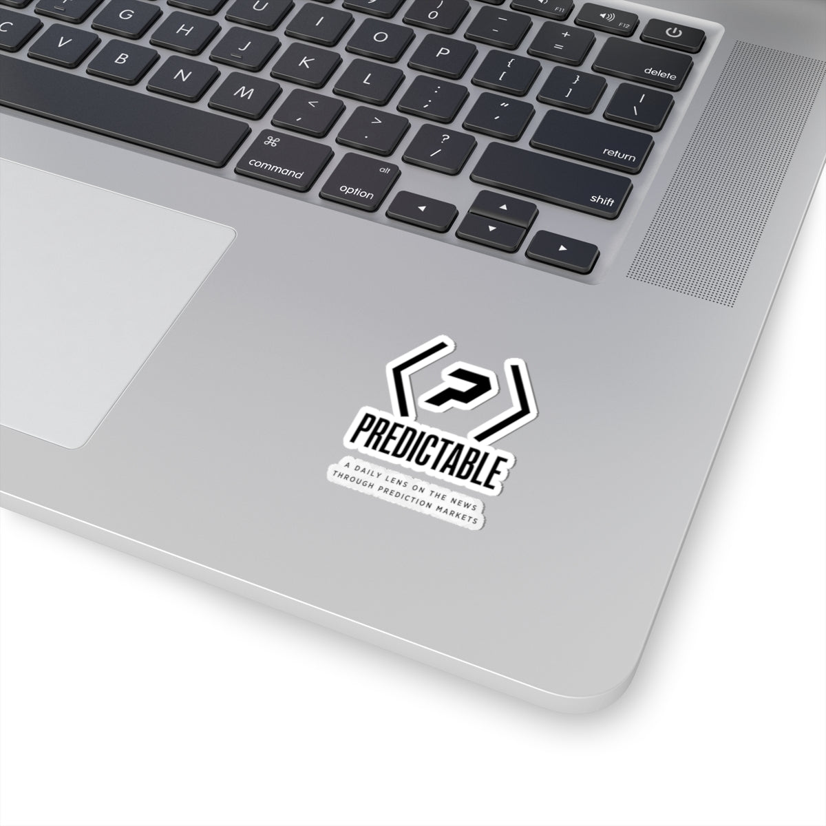 PREDICTABLE logo, wordmark and tagline sticker on a silver laptop.