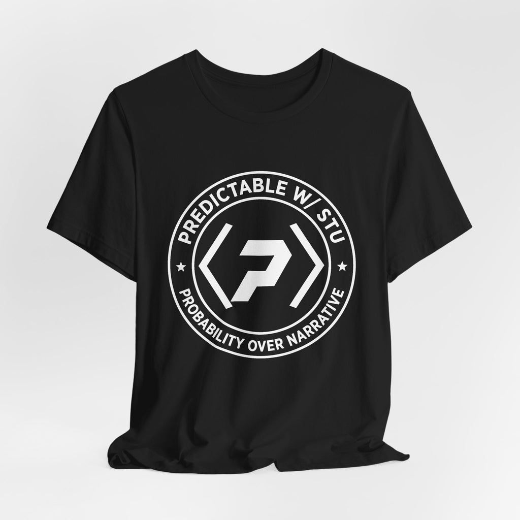 Black PREDICTABLE Badge Crest Tee draped against a light gray backdrop.